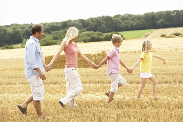 Familie lopen samen via zomer geoogst veld — Stockfoto