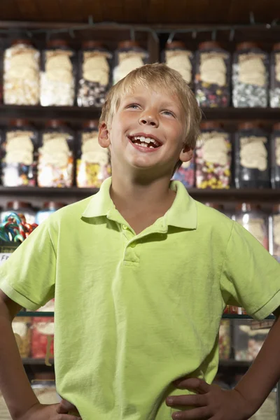 Взволнованный мальчик стоял в магазине сладостей — стоковое фото