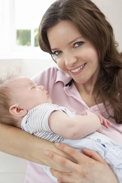 Primer plano de cariñosa madre acurrucado bebé niño en casa — Foto de Stock
