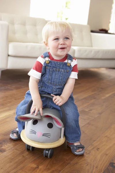 Ung pojke leker med tur på leksak musen hemma — Stockfoto