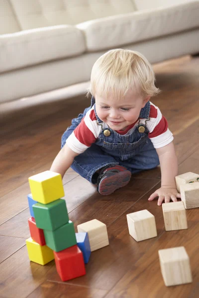 Junge spielt zu Hause mit farbigen Blöcken — Stockfoto