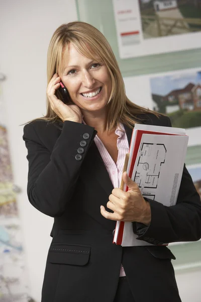 Young business woman talking on cellphone and holding document with smiling — Stock Photo, Image