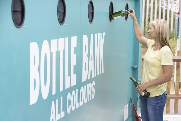 Mulher no centro de reciclagem descarte de vidro no banco de garrafas — Fotografia de Stock