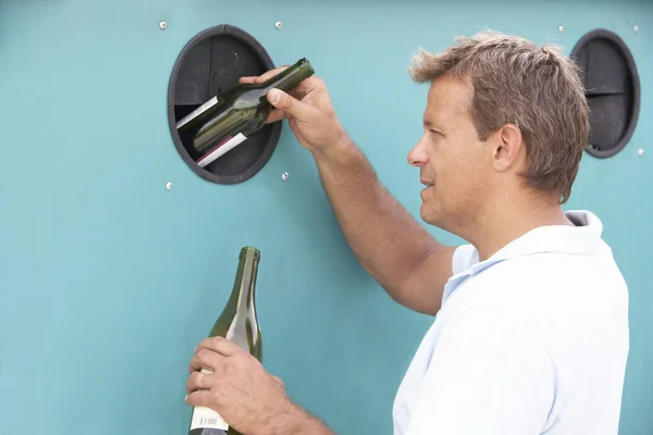 Man een groene fles te gooien in een prullenbak — Stockfoto