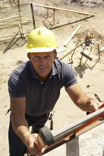 Construction Worker Climbing Ladder On Building Site For New Hom — Stock Photo, Image