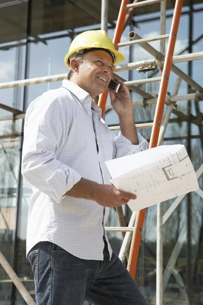 Arquiteto com planos fora da nova casa conversando no telefone móvel — Fotografia de Stock