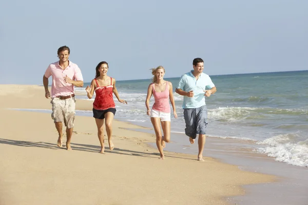 Grupo de amigos disfrutando de vacaciones en la playa — Foto de Stock