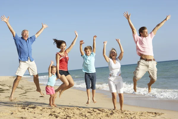 Három generációs családi tengerparti nyaralás jumping portréja — Stock Fotó