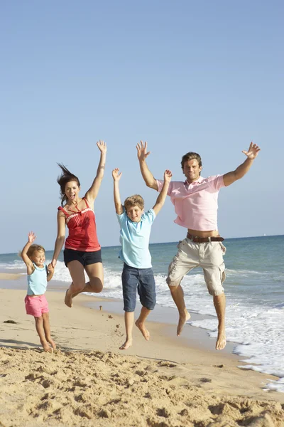 Retrato de la familia en vacaciones de playa saltando en el aire —  Fotos de Stock