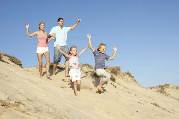 Familia disfrutando de vacaciones en la playa corriendo por la duna — Foto de Stock