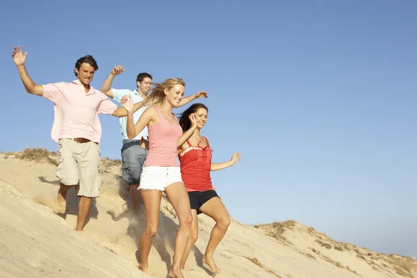 Gruppo Amici Godersi Vacanze Sulla Spiaggia Correndo Giù Dune — Foto Stock