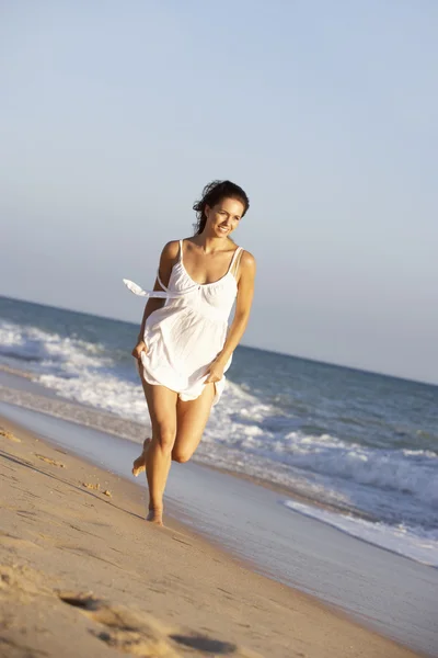 Νεαρή γυναίκα που τρέχει κατά μήκος το καλοκαίρι παραλία — Φωτογραφία Αρχείου