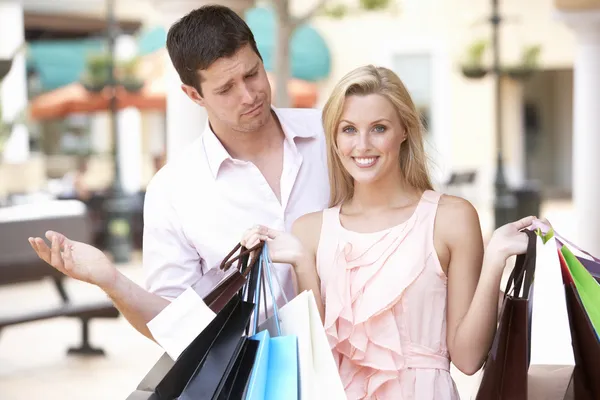 Człowiek sfrustrowany z kobieta na zakupy razem — Zdjęcie stockowe