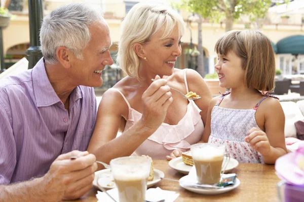 Abuelos con nieta disfrutando de café y pastel en Caf —  Fotos de Stock
