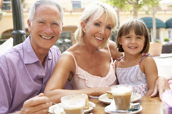 Grandparents With Granddaughter Enjoying Coffee And Cake In Caf — Stock Photo, Image