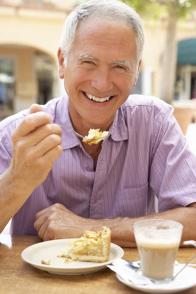 Hombre mayor disfrutando de café y pastel en Caf — Foto de Stock