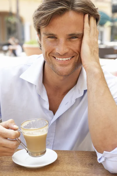 Ung man njuter av kopp kaffe i caf — Stockfoto