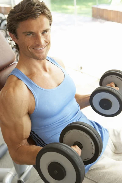 Hombre trabajando con pesas en el gimnasio —  Fotos de Stock