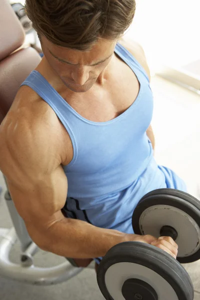 Hombre trabajando con pesas en el gimnasio — Foto de Stock