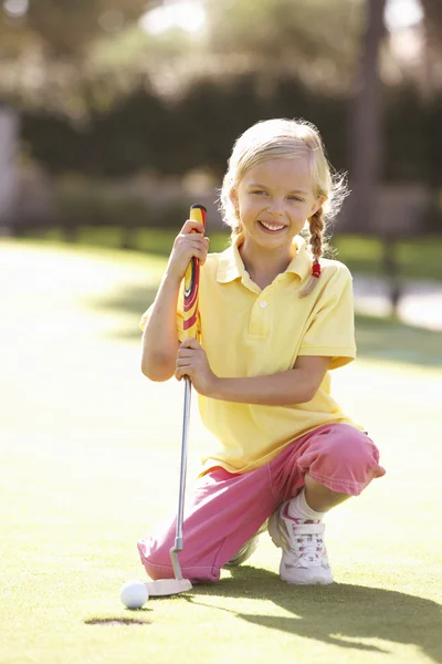 Młoda dziewczyna praktykujących golfa na umieszczenie na zielono — Zdjęcie stockowe