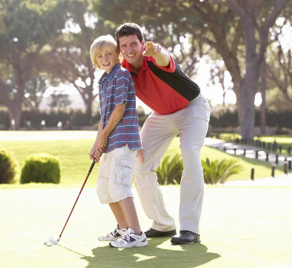 Padre enseñando hijo a jugar golf en poner en verde — Foto de Stock