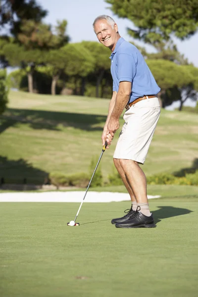 ゴルフ場のグリーンを置くシニア男性ゴルファー — ストック写真