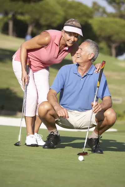 グリーンでのパットをライニングのゴルフコースでゴルフ年配のカップル — ストック写真
