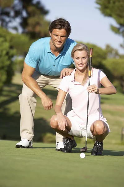 グリーンでのパットをライニングのゴルフコースでゴルフのカップル — ストック写真