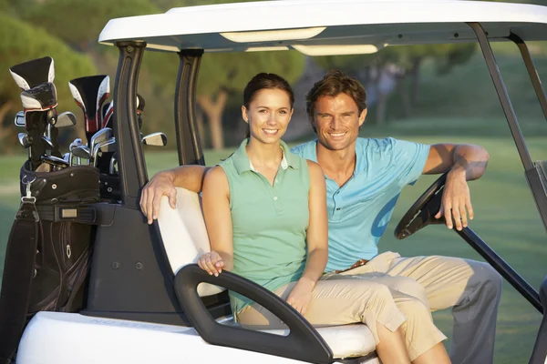 Paar rijden in golf buggy op golfbaan — Stockfoto