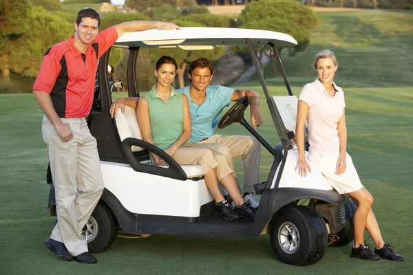 Grupo de amigos montando no buggy de golfe no campo de golfe — Fotografia de Stock