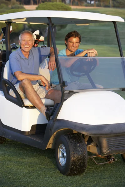 Twee mannelijke golfspelers in golf buggy rijden op golfbaan — Stockfoto