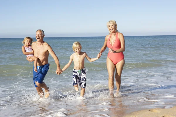 Nagyszülők, unokák, élvezve a strand holiday együtt — Stock Fotó