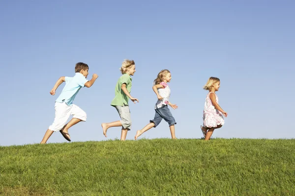 Crianças pequenas correndo pelo campo — Fotografia de Stock