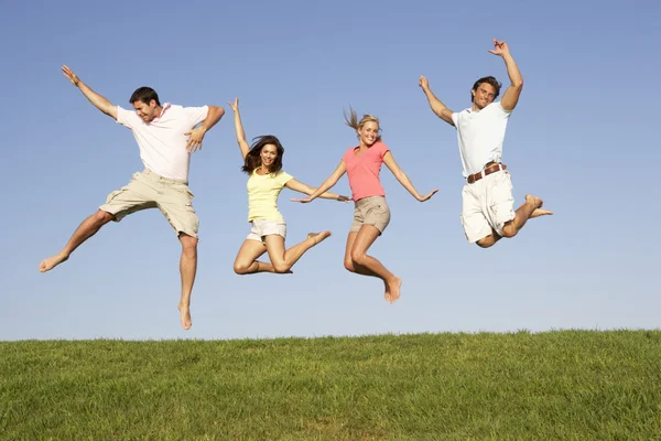 Young couples jumping in air — Stock Photo, Image
