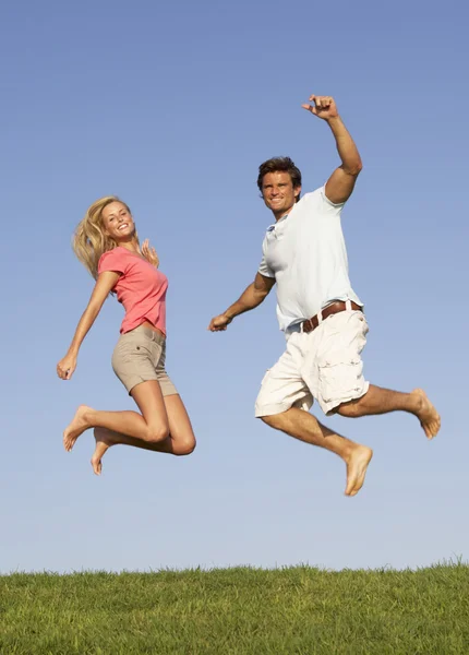 Ungt par hoppar i luften — Stockfoto