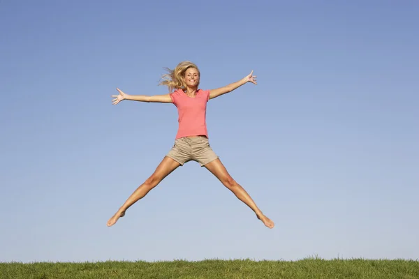 Młoda kobieta skacze w powietrzu — Zdjęcie stockowe