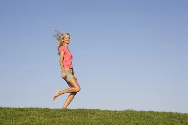 Giovane donna che corre attraverso il campo — Foto Stock