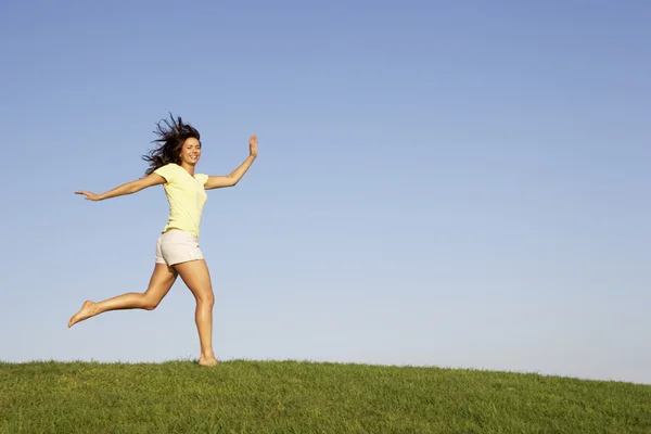 Молода жінка біжить полем — стокове фото