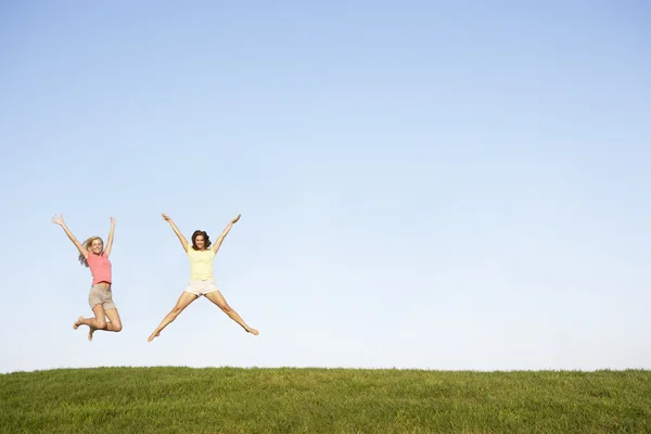 Mujeres jóvenes saltando en el aire — Foto de Stock