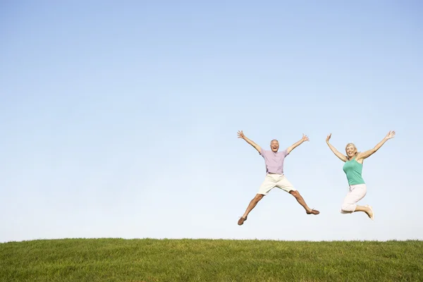 Äldre par hoppar i luften — Stockfoto
