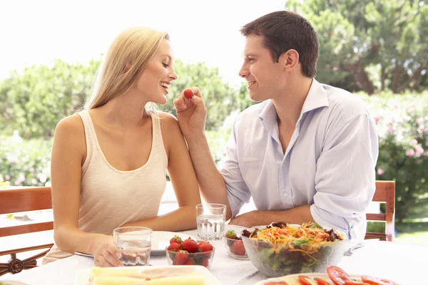 Casal jovem comendo ao ar livre — Fotografia de Stock