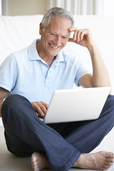 Старший мужчина с помощью ноутбука — стоковое фото