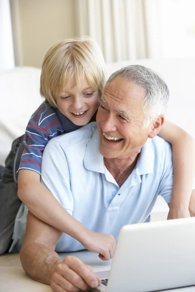 Hombre mayor con chico joven usando computadora portátil — Foto de Stock