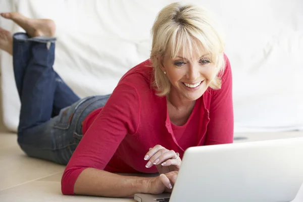 Mulher de meia idade em seu computador portátil — Fotografia de Stock