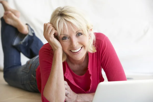 Mulher de meia idade em seu computador portátil — Fotografia de Stock