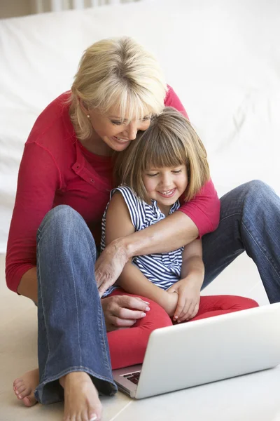 Mujer de mediana edad con chica joven usando computadora portátil —  Fotos de Stock
