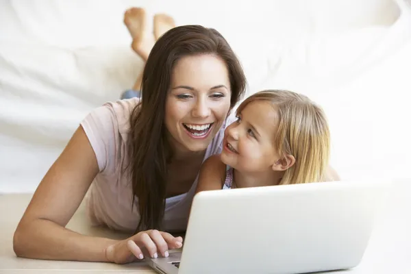 Mujer joven con chica usando ordenador portátil —  Fotos de Stock