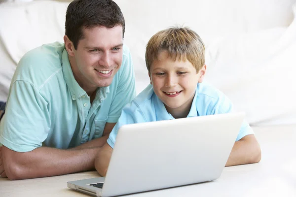 Young man with child on laptop computer — Stock Photo, Image