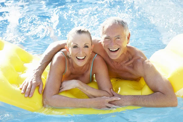 Старшая пара веселится в бассейне — стоковое фото