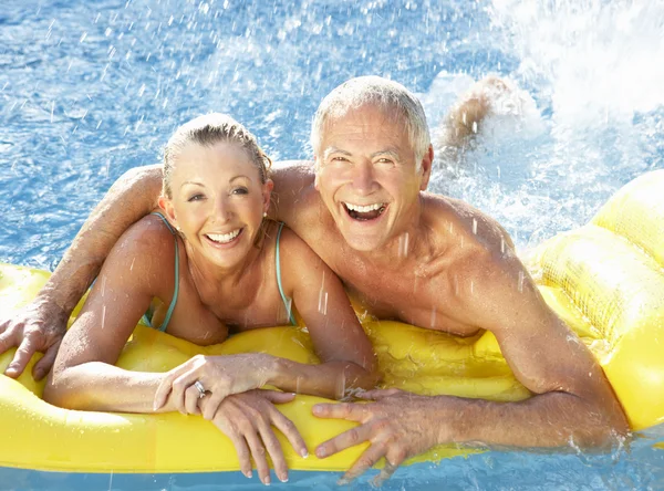 Starší pár, zábava v bazénu — Stock fotografie